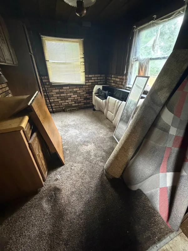 Family room packed with carpet rolls and furniture, before