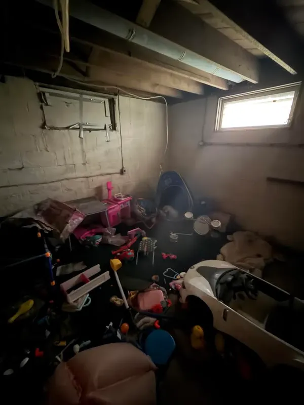 Basement full of toys and clutter, before