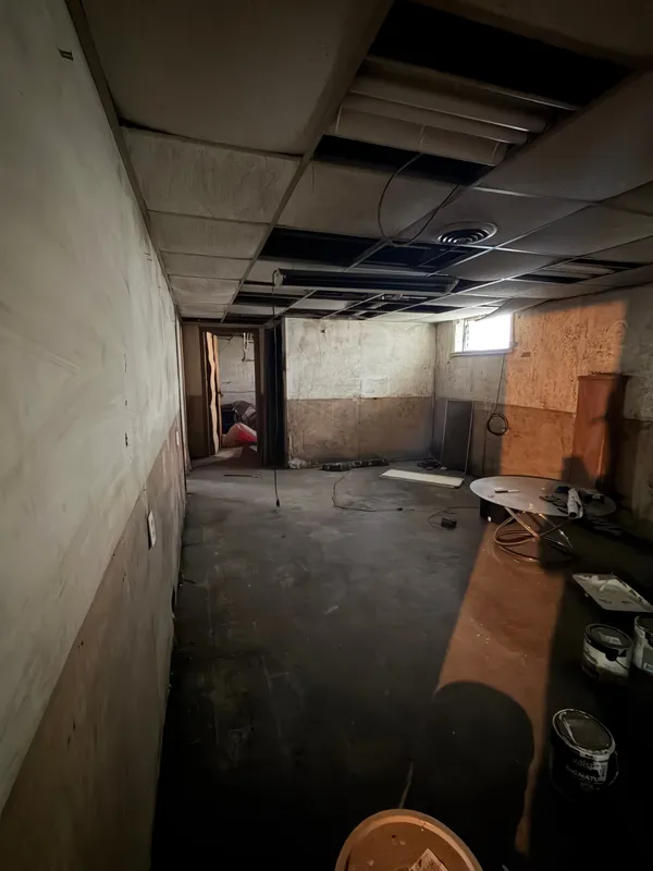 Basement with leftover junk under a drop ceiling, before