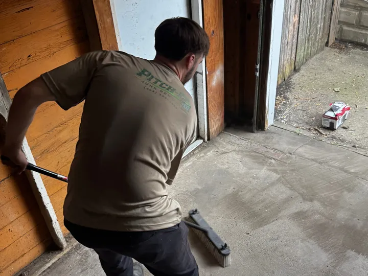 Sweeping the garage floor clean after a cleanout